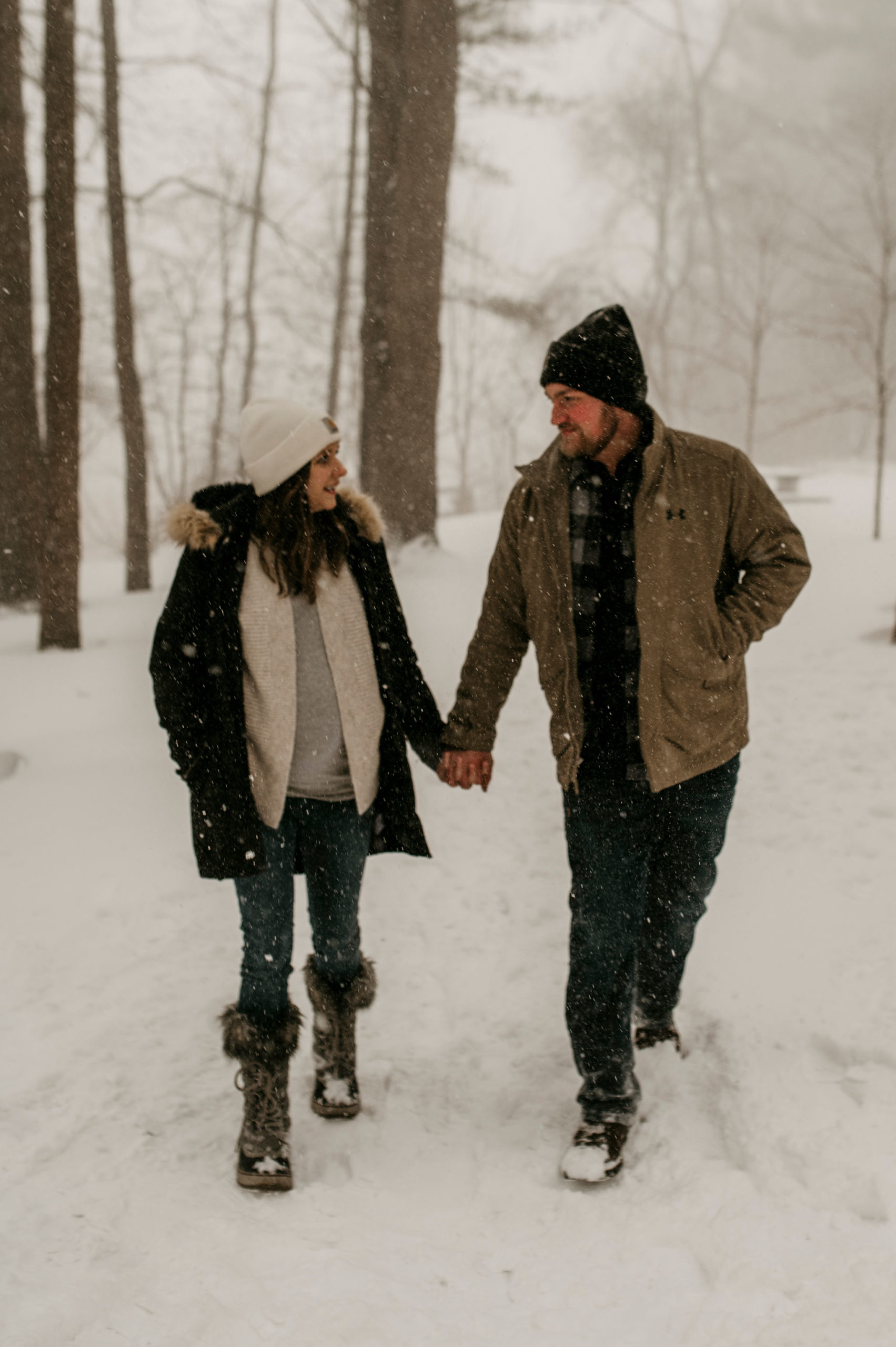 couple walking and holding hands in a snowy forest | Tips For Your New York Winter Engagement or Elopement