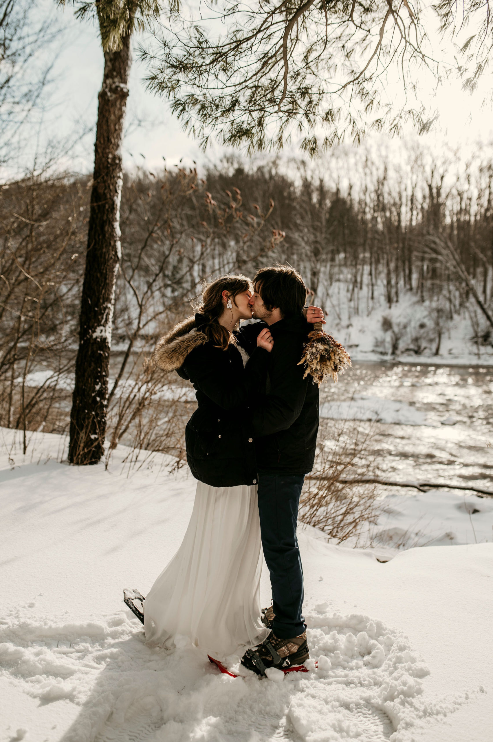 bride and groom hugging and kissing in the snow | Tips For Your New York Winter Engagement or Elopement