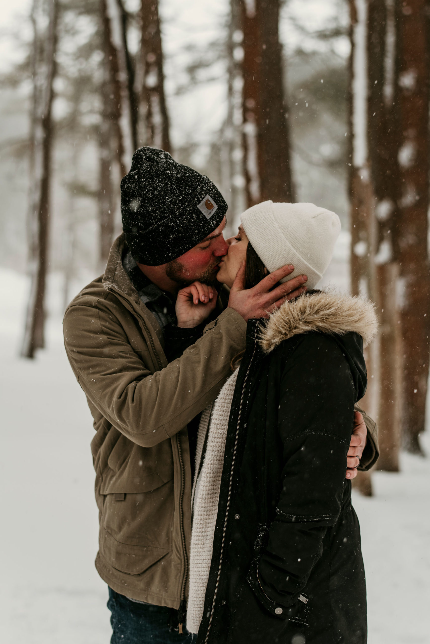 couple kissing in a snowy forest | Tips For Your New York Winter Engagement or Elopement