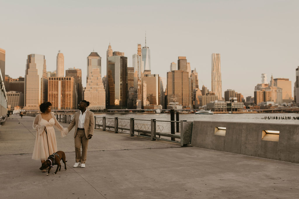 couple walking their dog in new york city with the city skyline