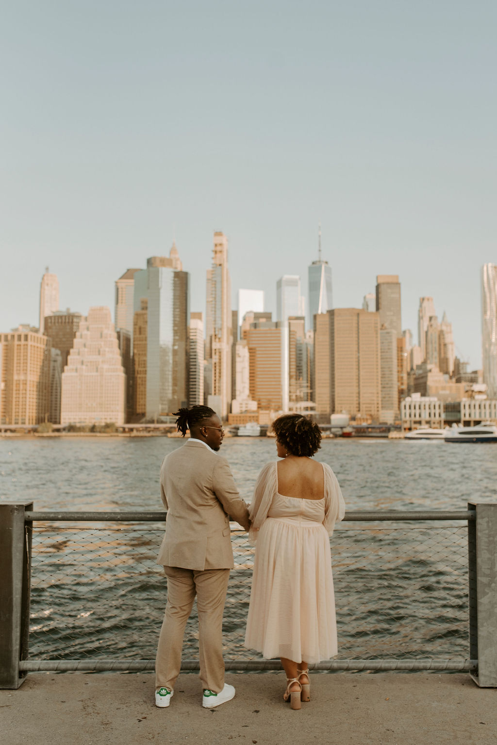 couple facing away from the camera looking at the new york city skyline