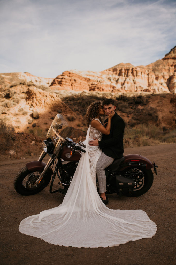 Couple sitting on motorcycle in the desert for elopement pictures