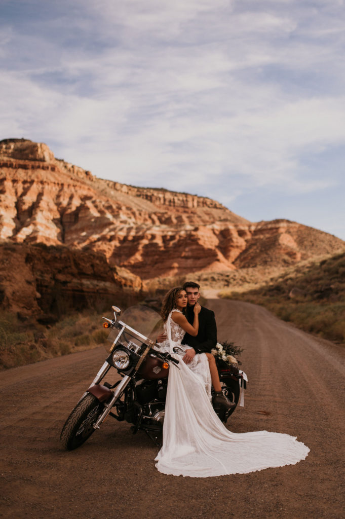 Couple sitting on motorcycle posing for photos in the Utah desert