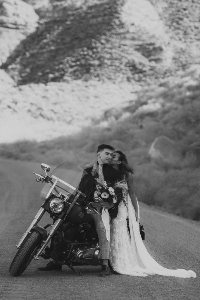 Couple posing on motorcycle for photos in the Utah desert