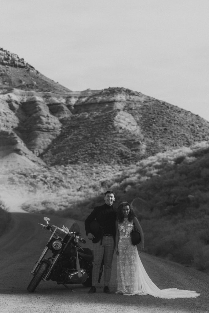Couple posing with motorcycle for photos in the Utah desert