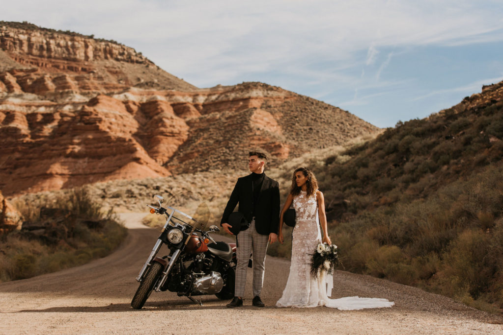 Couple posing with motorcycle for photos in the Utah desert