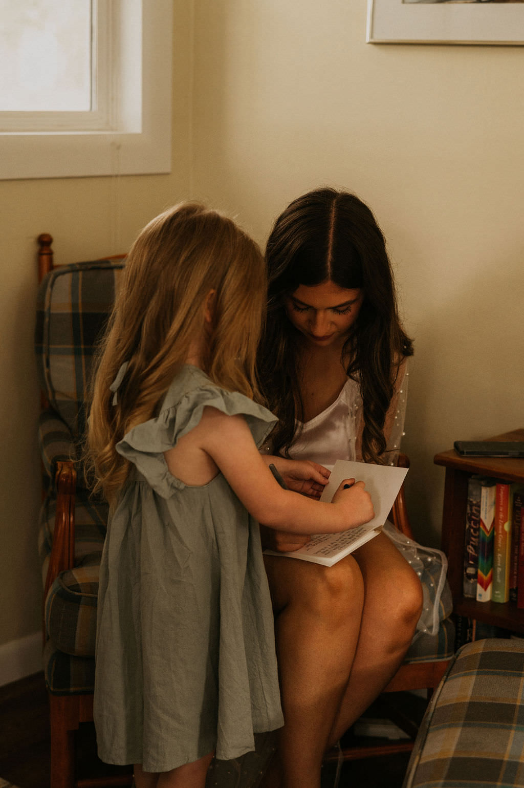 Bride writing vows and daughter helping to make it look nicer.