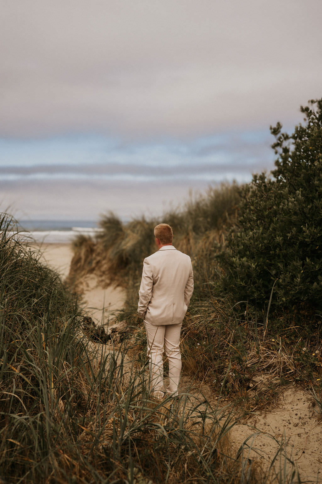 Groom waiting for first look at the beach elopement location.