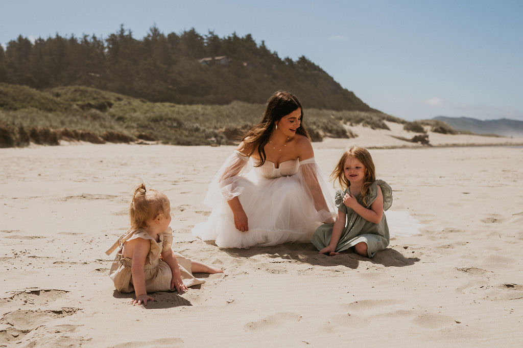 Bride at the beach during her elopement with her daughters.