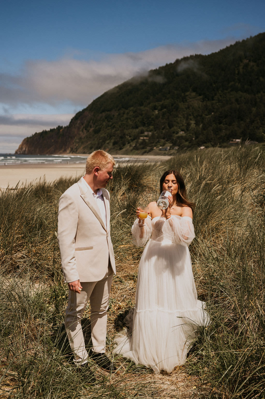 Bride and Groom during their intimate beach elopement drinking their favorite drink. 